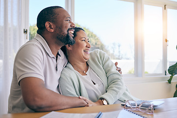 Image showing Love, laughing and hugging with a senior couple in their home, sitting by a table while thinking of a future retirement. Comic, funny or humor with a mature man and woman bonding together in a house