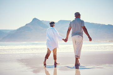 Image showing Holding hands, love and an old couple walking on the beach in summer with blue sky mockup from behind. Care, romance or mock up with a senior man and woman taking a walk on the sand by the ocean