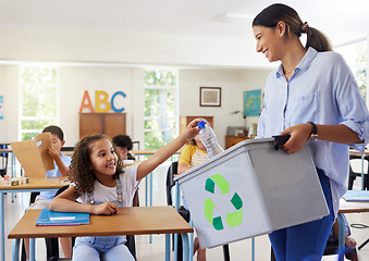 Image showing Teacher, recycle bin and girl in classroom throwing trash for cleaning, climate change or eco friendly in school. Recycling plastic, learning and education with happy student or kid in kindergarten.