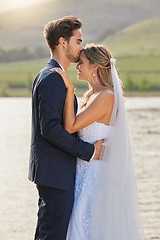 Image showing Love, wedding and a couple kissing by a lake outdoor in celebration of marriage for romance as newlyweds. Water, summer or kiss with a bride and groom bonding together in tradition after ceremony