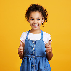 Image showing Thumbs up, girl and happy portrait isolated with a orange background in studio and yes gesture. Youth, happiness and agreement kid hand sign with a smile showing positive, thank you and motivation