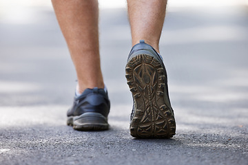 Image showing Fitness, shoes and walking with a man on a street during a cardio or endurance workout outdoor. Back, exercise and health with a male runner or athlete training on a street for wellness or lifestyle