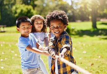 Image showing Fun, games and kids playing tug of war together outdoor in a park or playground in summer. Friends, diversity and children pulling a rope while being playful fun or bonding in a garden on a sunny day