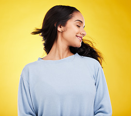 Image showing Freedom, shake hair and woman in studio with beauty and smile, satisfaction and gen z, fashion on yellow background. Happiness, youth and Indian female is happy with haircare and cosmetics with shine