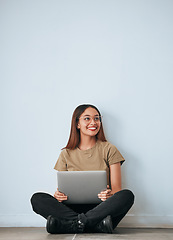 Image showing Laptop, student woman and smile by a wall with computer work for learning with happiness. University, college and house with floor sitting of a happy young person ready for studying with mockup