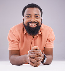 Image showing Happy, corporate and portrait of a black man by a table isolated on a studio background. Smile, business and an African employee excited about work sitting by a desk, working and looking professional