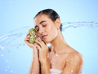 Image showing Kiwi, beauty and water splash of woman, skincare and wellness on blue background mockup. Wet model, shower and healthy fruits for natural benefits, detox nutrition and dermatology with diet vitamins