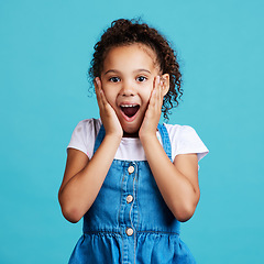 Image showing Portrait, surprise and girl with smile, wow and cheerful against a blue studio background. Face, female child and young person with shock, facial expression and gasp with joy, happiness and emoji