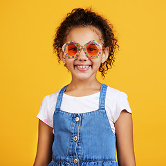 Image showing Girl child, happy and sunglasses in studio portrait with smile, summer style and yellow background. Mixed race model, female kid and fashion frame on face with kids clothes, aesthetic and lifestyle