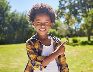 Image showing African boy, pointing and park portrait with smile, happiness or playful in outdoor sunshine. Young black child, point and hand gesture on grass in summer with excited face, happy and freedom to play