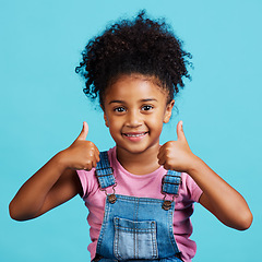 Image showing Little girl, portrait smile and thumbs up for winning, good job or success against a blue studio background. Happy child face smiling showing hand thumb emoji, yes sign or like for agreement or win