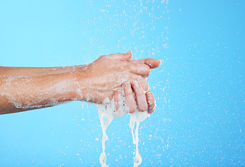 Image showing Woman, handwashing and water drops with soap isolated on blue background with skincare and hygiene. Cleaning hands, hydration and wellness with mockup, shower and foam product, dermatology and health