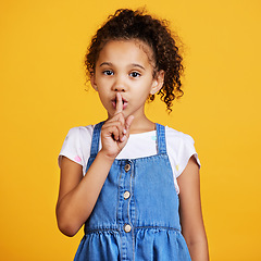 Image showing Studio, portrait and child with finger on lips for secret or gossip isolated on yellow background. Face of young girl kid model with hand on mouth for silence, hush or quiet about mystery or surprise