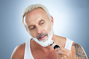 Image showing Mature man, beard and shaving cream for skincare, grooming or hair removal against studio background. Senior male face applying shave creme or foam product with brush for haircare or facial treatment