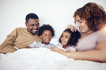 Image showing Family, father and mother with children on bed relaxing together for fun morning or holiday break at home. Happy dad, mom and kids relax and lying in bedroom enjoying comfort and bonding time