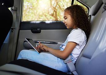Image showing Child in car, tablet and road trip with seatbelt for safety and device to watch educational video or online game. Technology, internet and summer travel, happy girl on backseat for drive or carpool.