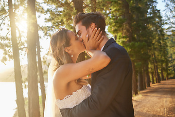 Image showing Wedding, love and couple and kiss in park, forest and nature for celebration of union, care and marriage. Bride, groom and kissing in garden for romance, intimate bridal event or celebrate commitment