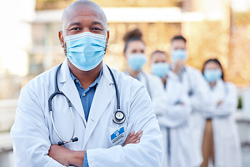 Image showing Covid mask, doctor and black man in leadership outdoor with arms crossed for medical and health insurance. Face portrait of healthcare worker with ppe for safety, compliance and corona virus wellness