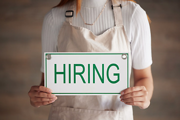 Image showing Woman, hands and hiring sign for small business recruitment, career or job opportunity against a studio background. Hand of female entrepreneur with apron holding billboard, label or poster for hire