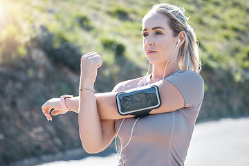 Image showing Fitness, serious woman and stretching arms with music earphones for exercise, start or workout in nature. Determined and fit female in focus listening to radio in arms warm up for training outdoors