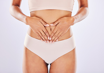 Image showing Hands, stomach and belly of a woman natural model with smooth skin isolated in a studio white background. Weight loss, diet and female touch abdomen for healthcare, fitness and nutrition