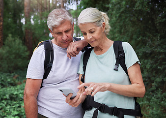 Image showing Hiking, forest and elderly couple with phone for gps, location or navigation while exploring together. Online, maps and active senior man with woman checking direction while backpacking in nature