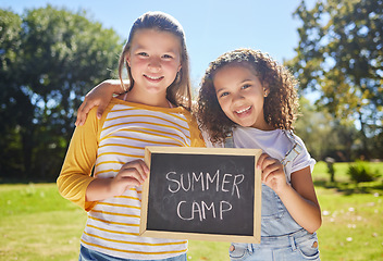 Image showing Summer camp, portrait or happy girls in park together for fun bonding, development or playing in outdoors. Young best friends smiling, hugging or embracing on school holidays outside with board sign