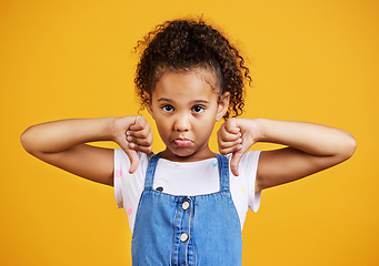 Image showing Sad, negative and portrait of a child with a thumbs down isolated on a studio background. Unhappy, fail and a girl kid with an emoji hand sign for frustration, disappointment and disagreement