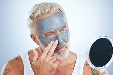 Image showing Man, mirror and clay mask for face skincare, wellness and organic cleaning with smile by studio background. Elderly male, hand and natural charcoal product for facial cosmetics for dermatology detox