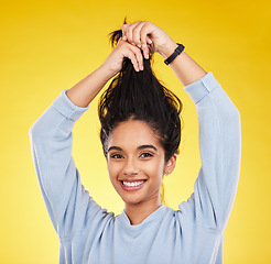 Image showing Young woman, haircare and playful, smile in portrait and hair in air with gen z and fashion on yellow studio background. Happiness, youth and silly Indian female, happy with growth with shine