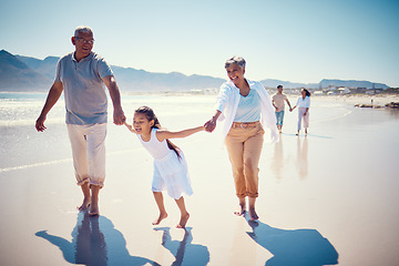 Image showing Beach, holding hands and playing, grandparents with girl, family walking on ocean sand together. Fun, vacation and happy senior man and woman with children bonding, quality time and summer in nature.