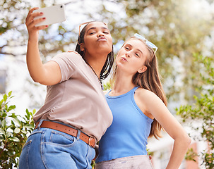 Image showing Selfie, kiss and women friends bonding, chilling or hanging out outdoor in the park. Love, friendship and happy interracial females taking cute picture with a pout together in nature in green garden.