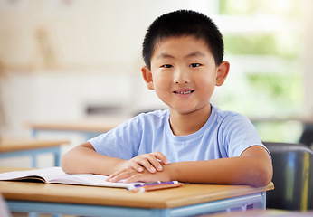 Image showing Learning, portrait and Asian boy in classroom for education, exam or studying with book. Preschool, development growth and smile of happy kid and student from Japan in kindergarten for knowledge.