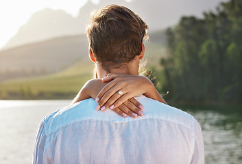 Image showing Engagement, hug and couple by lake for romantic holiday, vacation and honeymoon in nature together. Love, proposal mockup and hands of woman holding man for embrace, hugging and affection outdoors