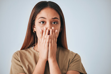 Image showing Portrait, woman and surprise in a studio with a female cover mouth from shock. Isolated, grey background and hands on a face of a young person model with wow, worry and alert reaction from secret