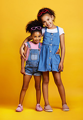 Image showing Children, hug and happy portrait of sisters in studio with love, care and support on yellow background. Cute young girl kids smile together for happiness, carefree and positive attitude for family