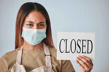 Image showing Covid, female business owner and closed sign in face mask in studio portrait for announcement, board or worry for future of shop. Entrepreneurship, woman or stress with poster, bankrupt or management