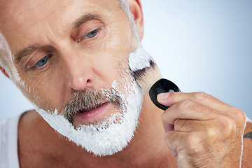 Image showing Man, beard and shaving cream for grooming, skincare or hair removal against a studio background. Closeup of male face applying shave creme or foam product with brush for haircare or facial treatment