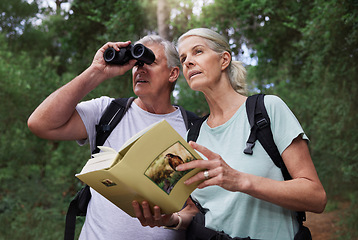 Image showing Book, bird watching and binoculars with old couple in nature for bonding, discovery and travel adventure. Search, hiking and view with senior man and woman in forest for explore, retirement and hobby