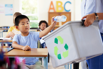 Image showing Teacher, recycle bin and kid in classroom throwing trash for cleaning, climate change or eco friendly in school. Recycling plastic, sustainable learning or education with boy student in kindergarten.