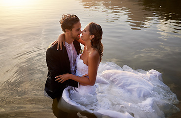 Image showing Wedding, water and wet bride with groom hug, kiss and standing in lake together with passion, smile and romance. Love, marriage and happy couple celebrate romantic, loving relationship in nature.