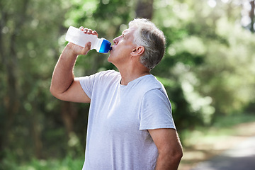 Image showing Man, exercise and outdoor drinking water for a run, workout and training for fitness. Senior male person with bottle for hydration, cardio health and wellness while running in nature and retirement