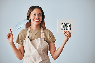 Image showing Coffee shop, covid and a woman holding an open sign in studio on a gray background after lockdown. Portrait, small business startup and cafe with a female entrepreneur indoor to display advertising