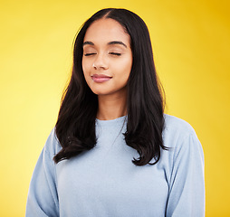 Image showing Indian woman with eyes closed, meditation and zen with peace and calm isolated on yellow studio background. Mental health, wellness and balance with stress relief, young female relax with mindfulness