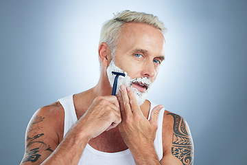 Image showing Senior man, razor and shaving beard with cream for grooming, skincare or hair removal against a studio background. Portrait of mature male with shaver, creme or foam for hygiene or facial treatment