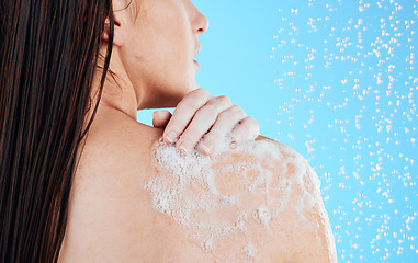 Image showing Shower, woman hands and back washing in a studio with a female bodycare for beauty routine. Water, model and wellness of young person cleaning with soap for hygiene and grooming with blue background