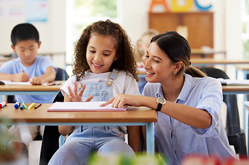 Image showing Teacher, learning and helping girl in classroom for knowledge, studying and assessment. Preschool smile, development and happy kid or student with woman for education with notebook in kindergarten.