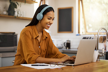 Image showing Typing, remote work and woman on laptop happy at home working on project, strategy and planning in kitchen. Freelancer, business and girl with headphones for music, working online and streaming audio