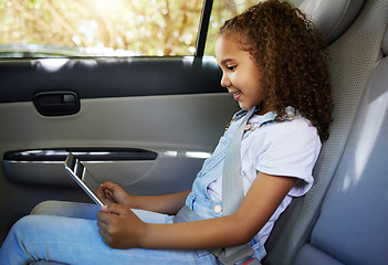 Image showing Happy, road trip and a child in a car with a tablet for a movie, cartoons or video. Smile, travel and a girl sitting in a vehicle with tech, streaming online and enjoying a film for entertainment