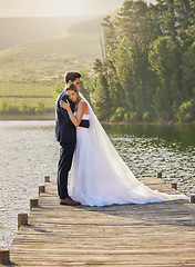 Image showing Wedding couple, hug and relax by lake for honeymoon, love or romantic getaway in nature. Calm woman hugging man in happy marriage relaxing by the water together enjoying the loving embrace outdoors